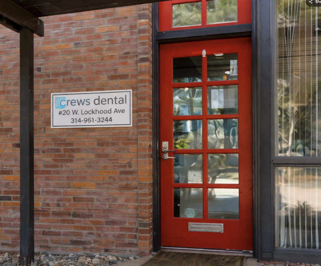 The red front door of Crews Dental West at 20 W Lockwood Avenue in Webster Groves